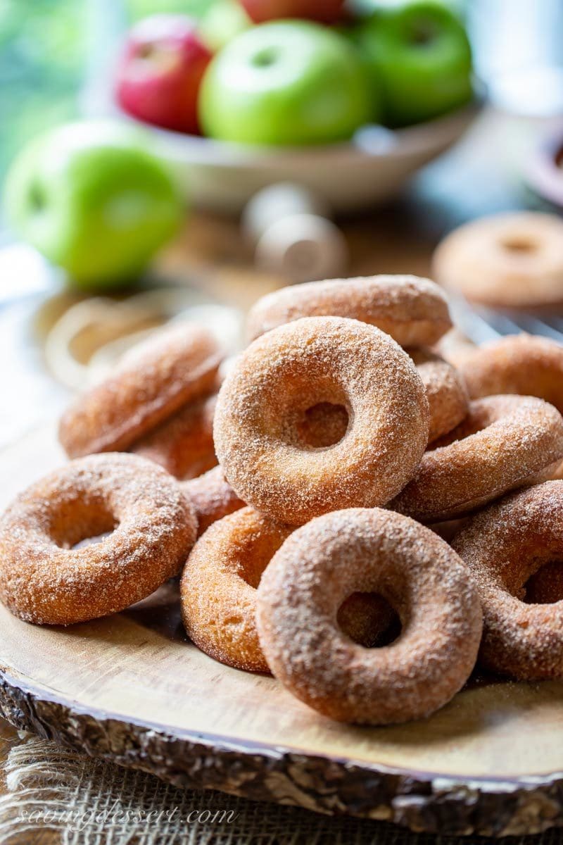 a pile of baked Apple Cider Doughnuts coated in cinnamon and sugar