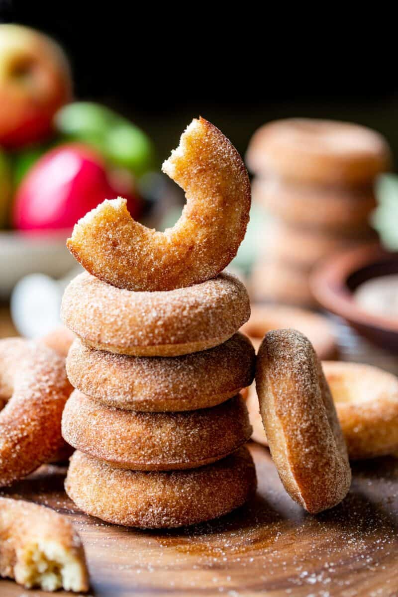 A stack of apple cider doughnuts on a cutting board