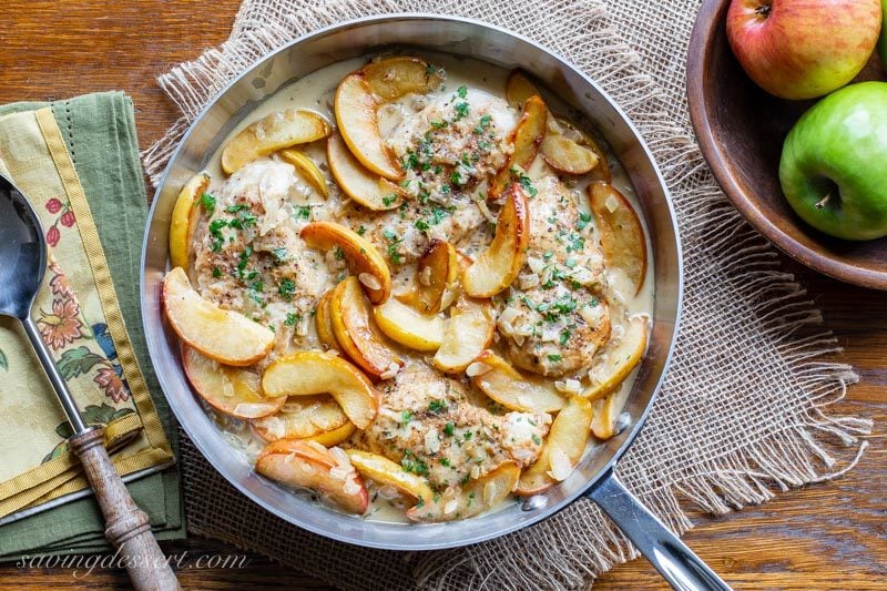 Skillet with chicken breasts, apples and onions