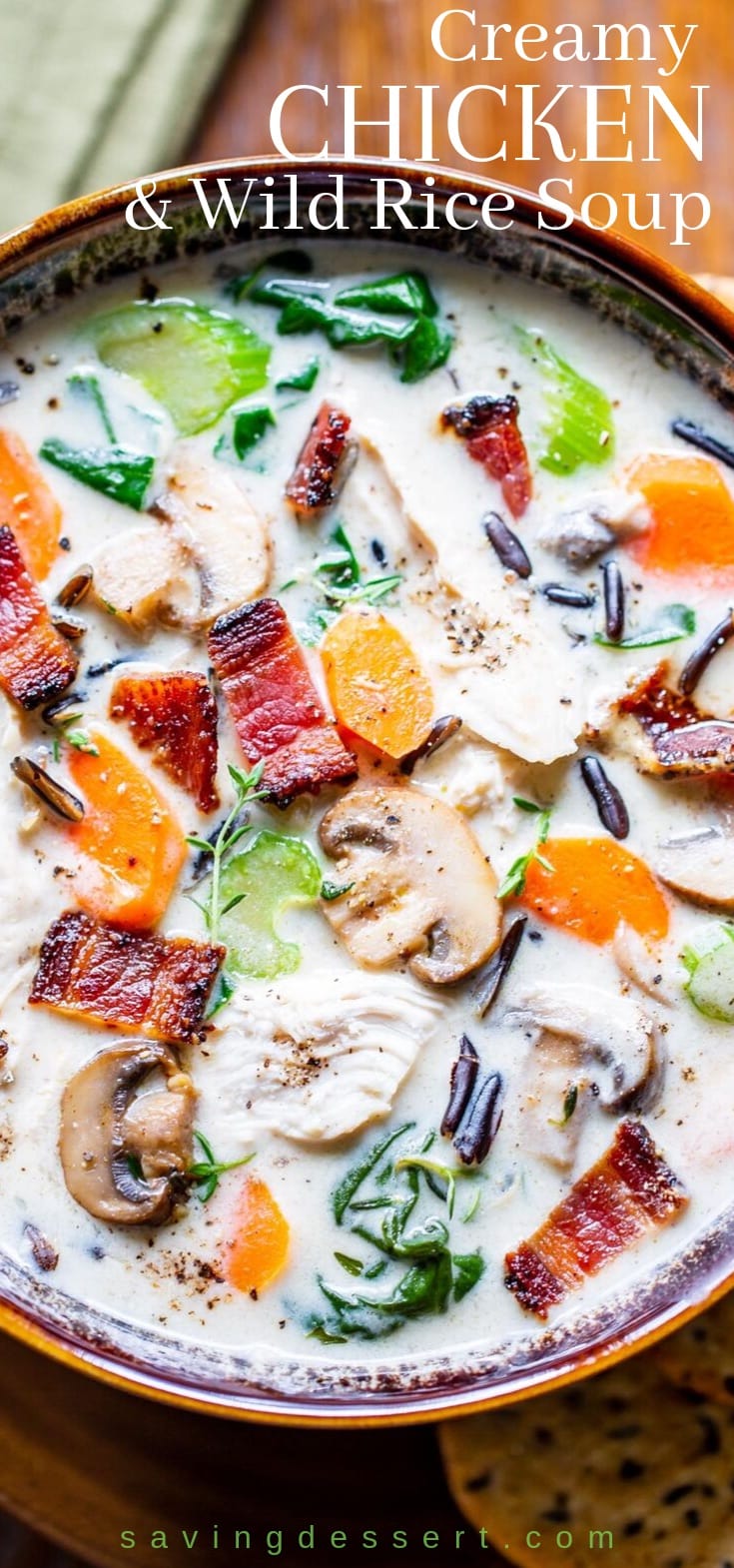 A bowl of creamy chicken and wild rice soup with mushrooms and bacon on top