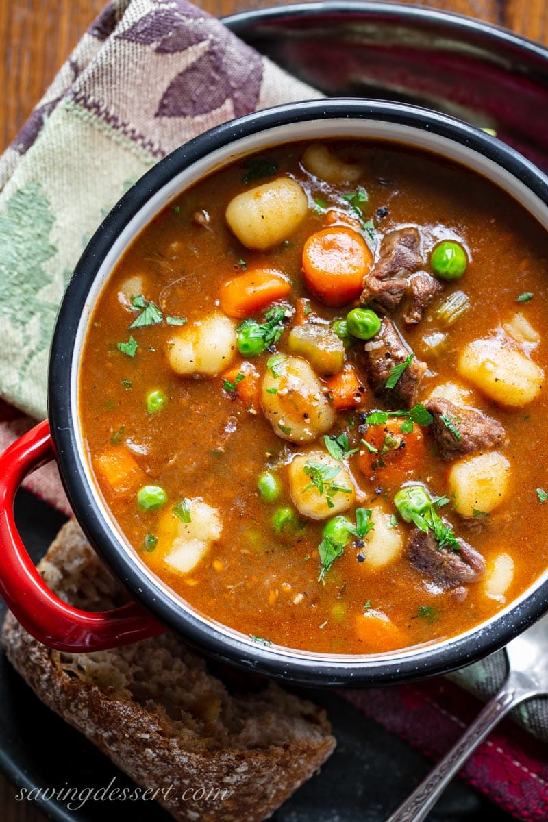 An overhead view of a hearty bowl of beef and gnocchi soup