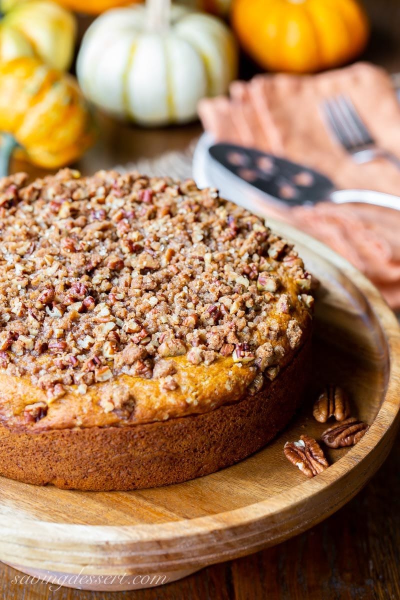 A round single layer pumpkin cake topped with chopped pecans