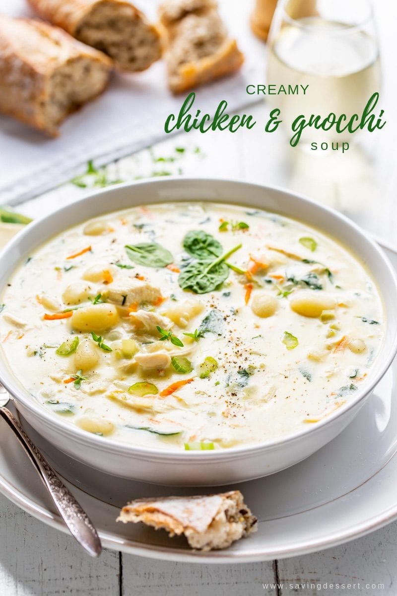 A bowl of creamy chicken and gnocchi soup with spinach. 