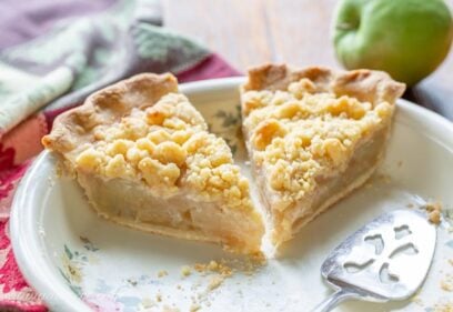 Two slices of Dutch apple pie in a pie plate with a spatula