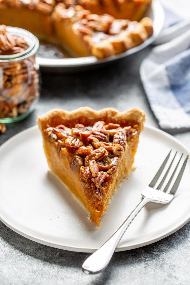 A slice of sweet potato pie with pecans and a caramel topping