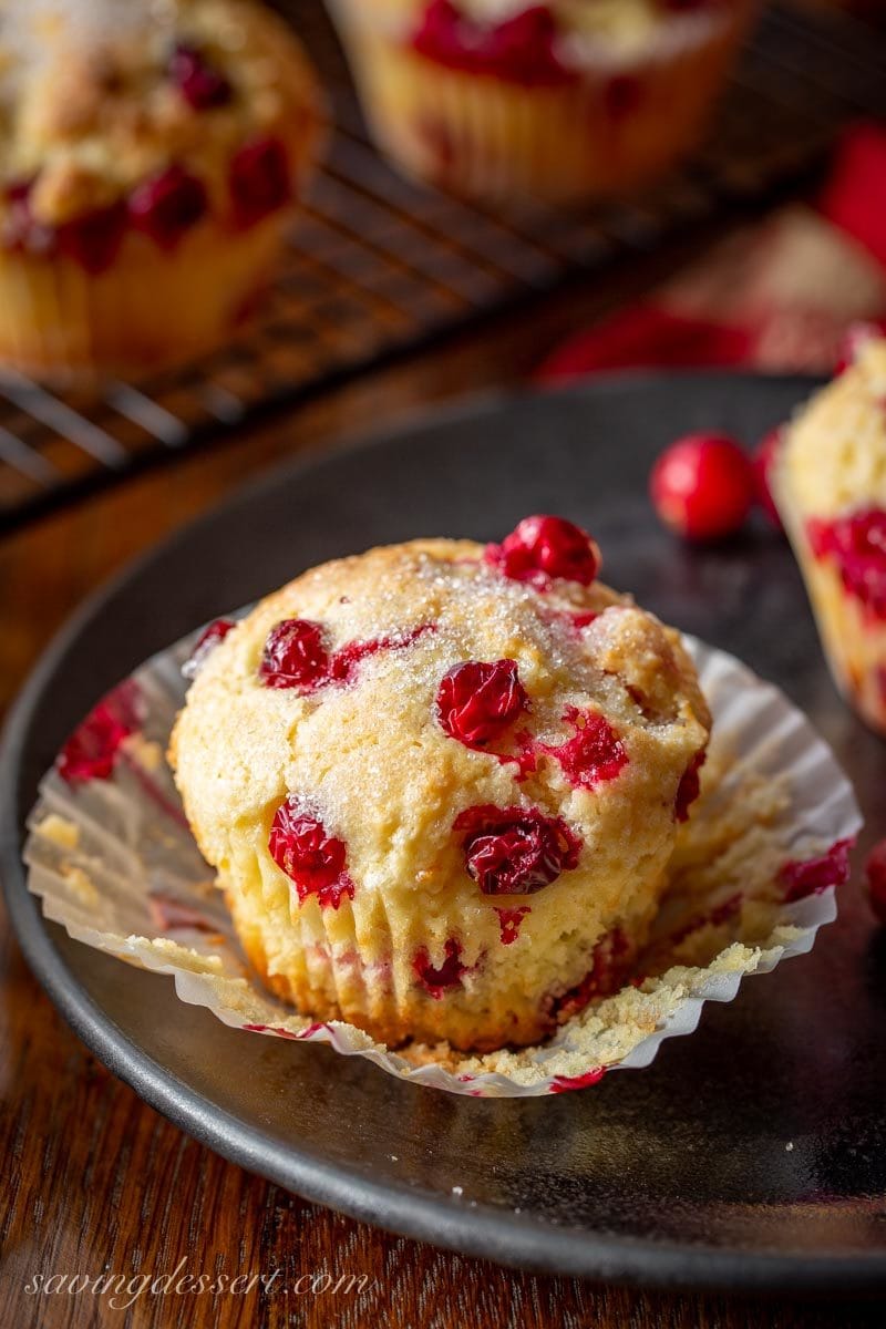 A ready to eat fresh cranberry orange muffin in a paper cupcake liner