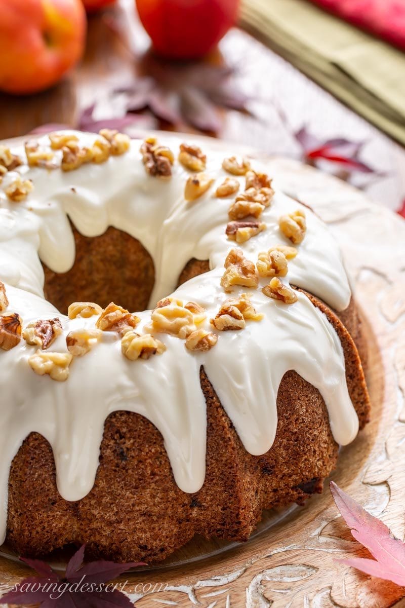 Fresh apple cake topped with a creamy icing and walnuts