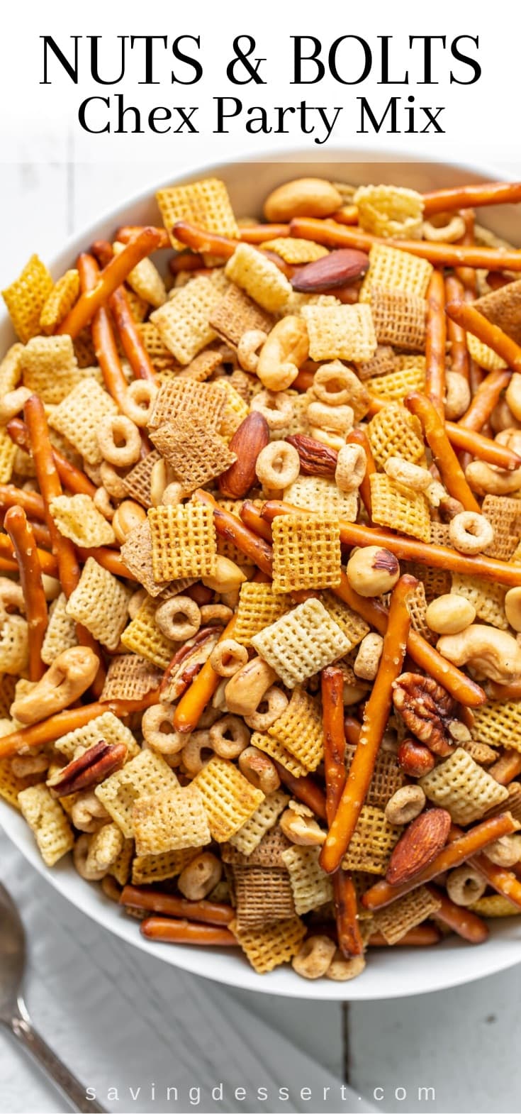 A big bowl of chex party mix with pretzels, cereal and nuts