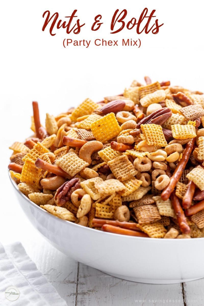 A big bowl of Party Chex Mix with Chex cereal, pretzel sticks, assorted nuts and Cheerios