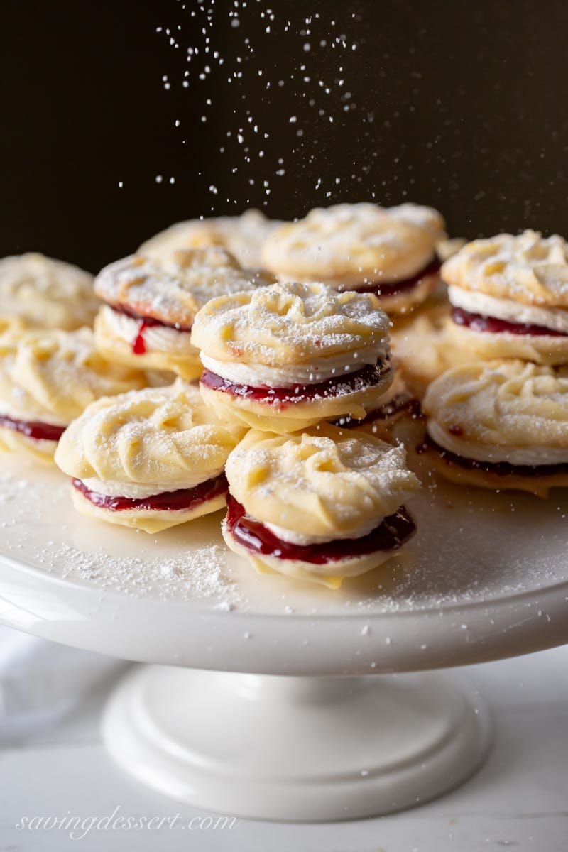 A platter of Viennese Whirls, little butter cookies piped into swirls sandwiched together with jam and buttercream and dusted with powdered sugar