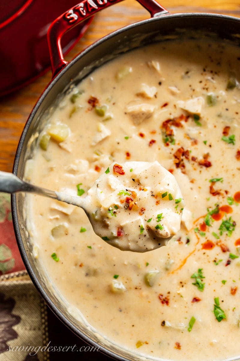 A pot of Buffalo Chicken Chowder with potatoes, hot sauce and crumble bacon