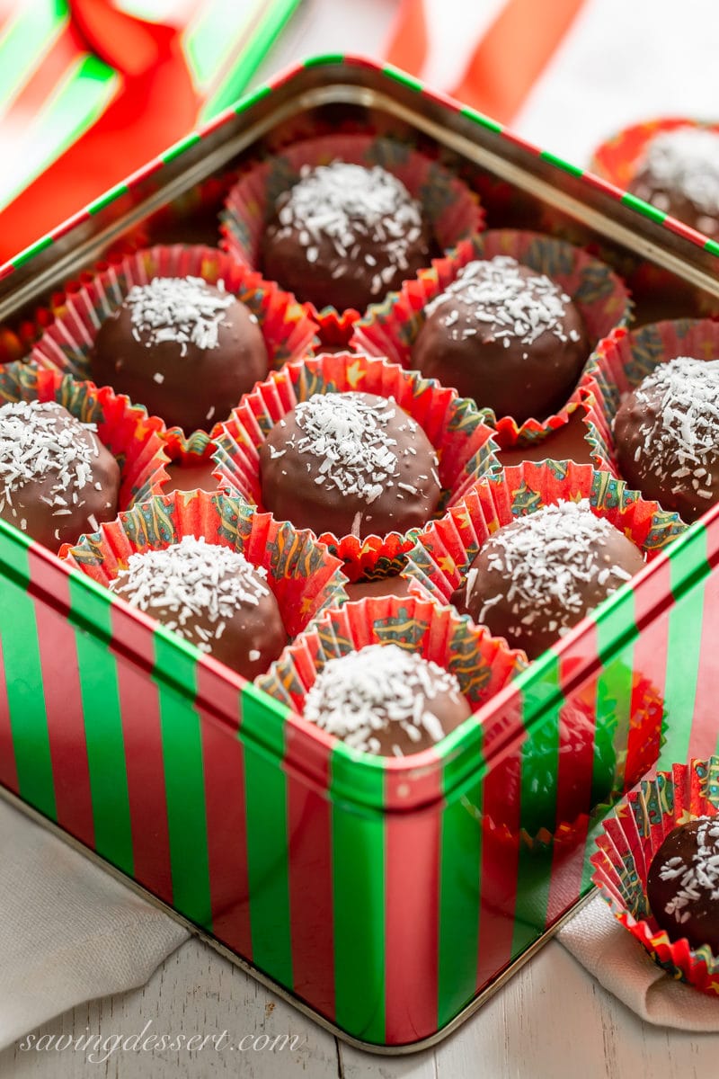 A holiday tin filled with chocolate coconut balls topped with shredded coconut