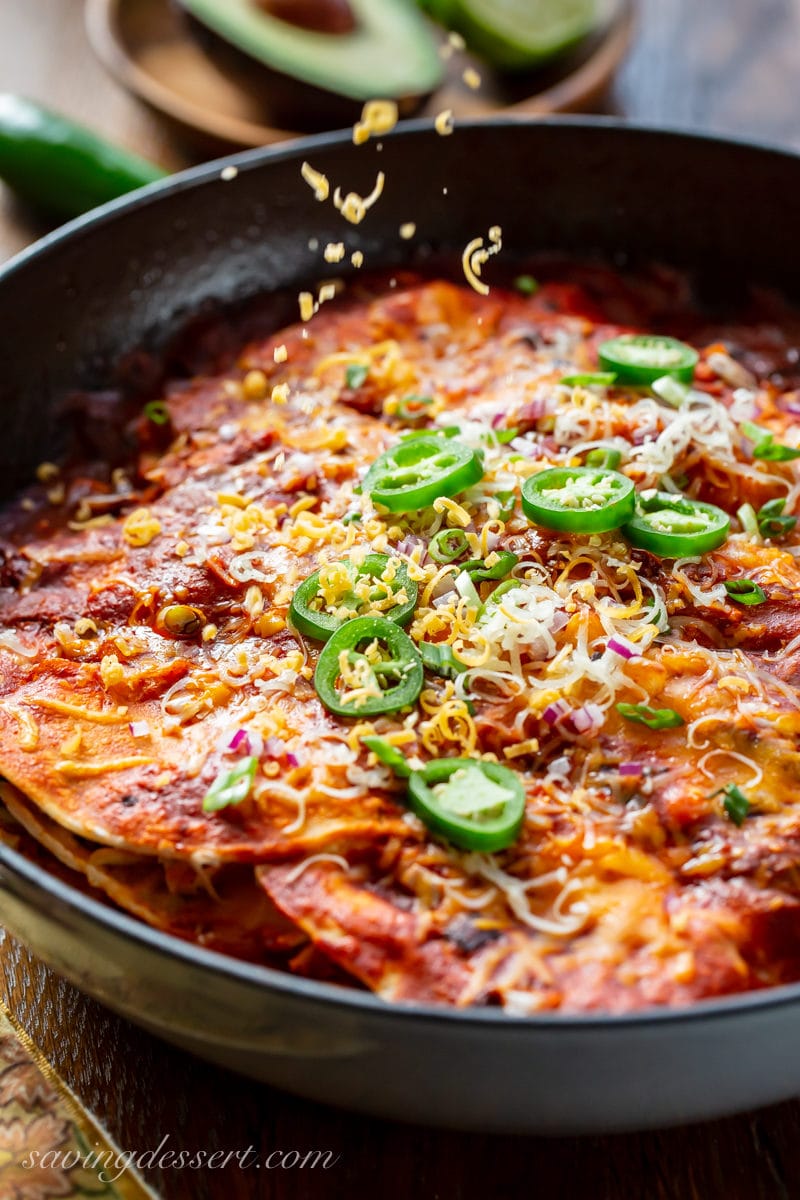 A pan with cheesy enchilada casserole topped with jalapeños. 