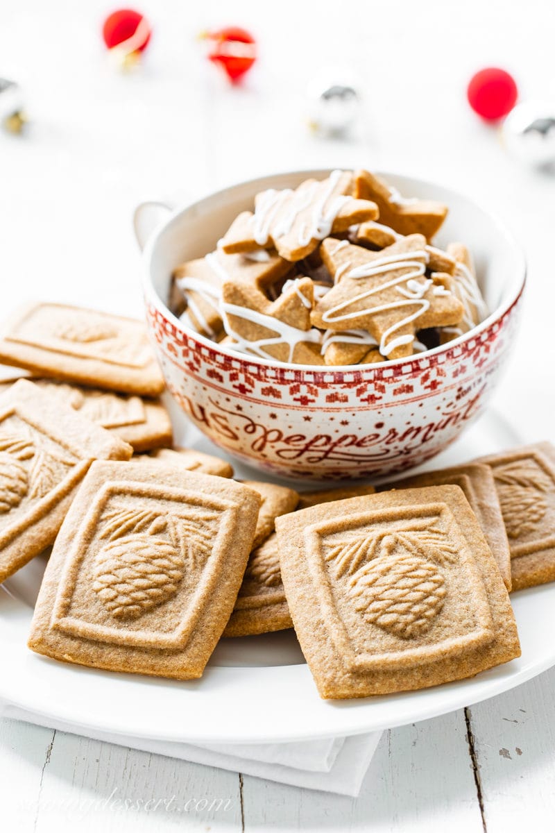 A platter and cup of molded Speculaas Spiced Cookies imprinted with a pine cone design