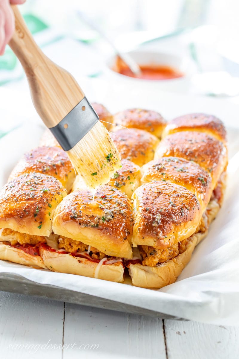 Parmesan sliders on a platter brushed with garlic butter and herbs