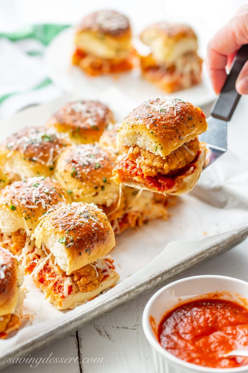A pan of cheesy Chicken Parmesan sliders served with pizza sauce