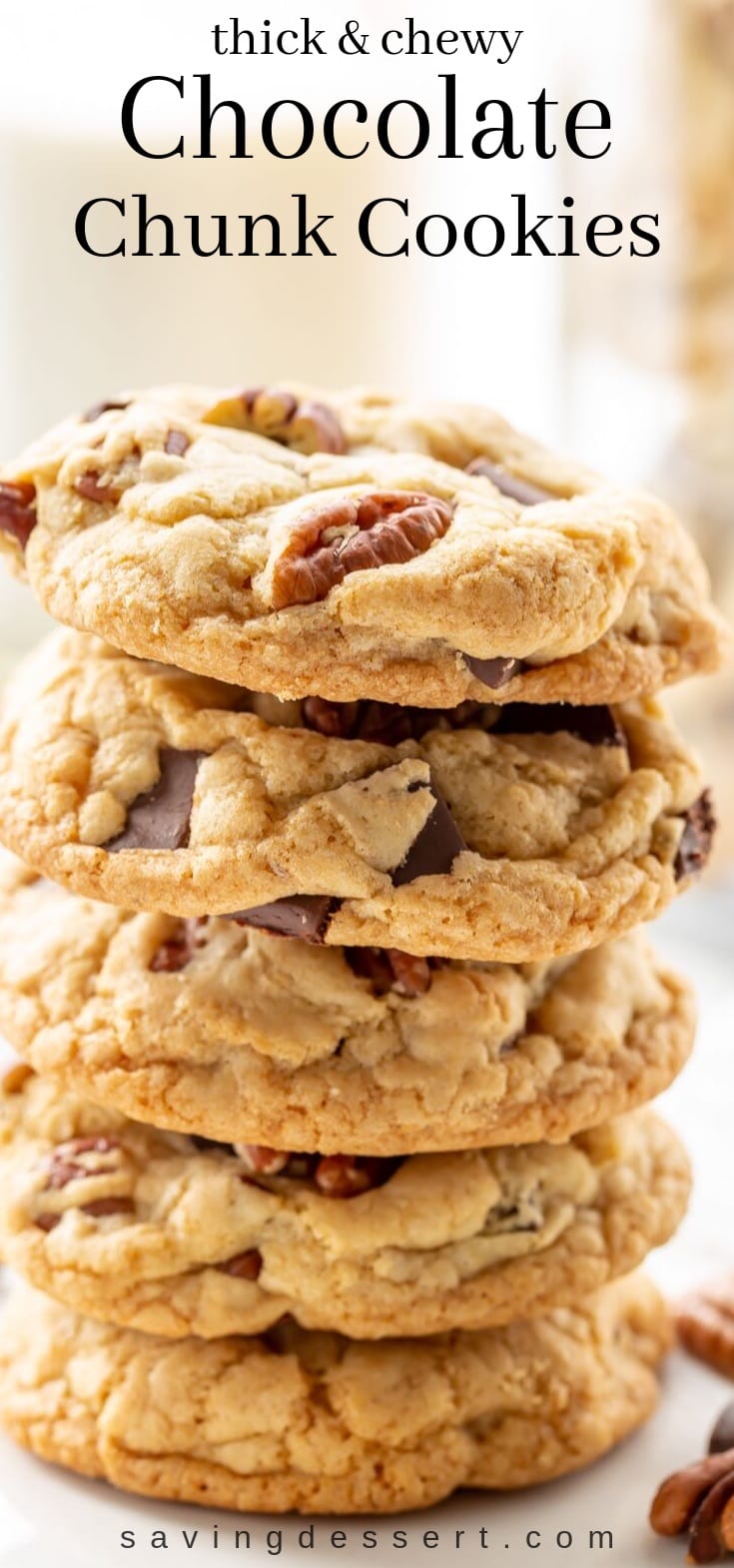 A stack of thick and chewy chocolate chunk cookies with pecans