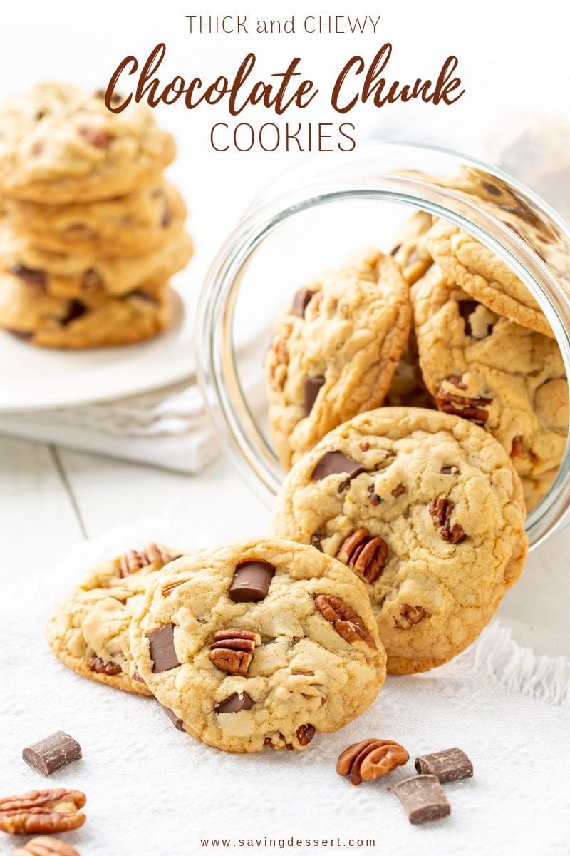 A glass jar filled with thick and chewy chocolate chunk cookies with pecans