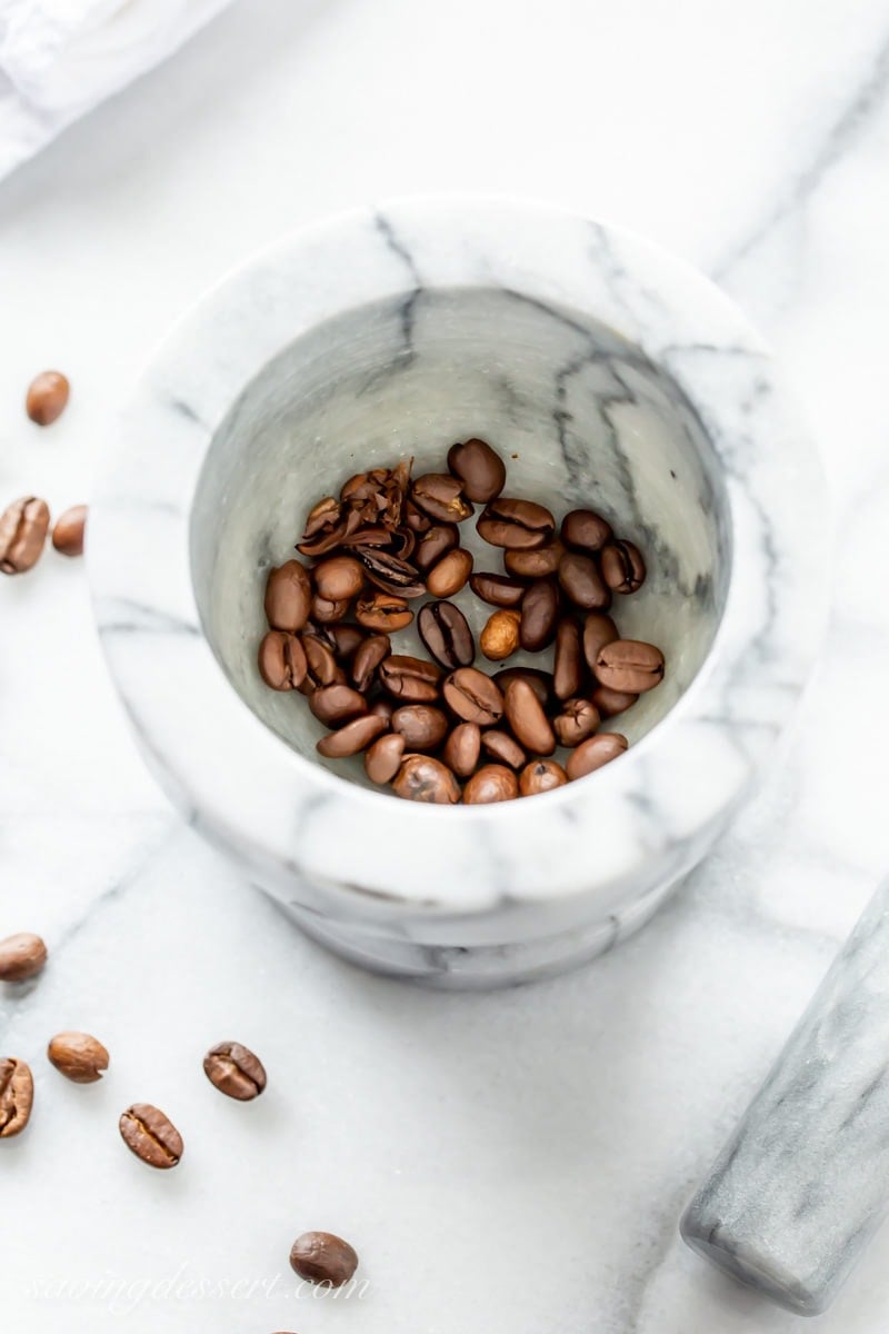 A mortar and pestle with whole coffee beans