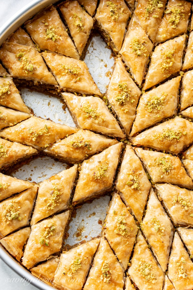 A round pan with Honey Pistachio Baklava cut into diamond shaped wedges