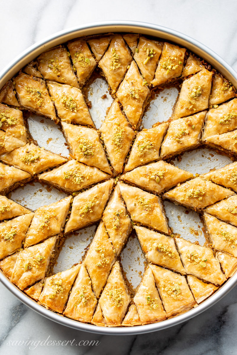a large pan of honey baklava cut into a diamond pattern with several pieces removed.