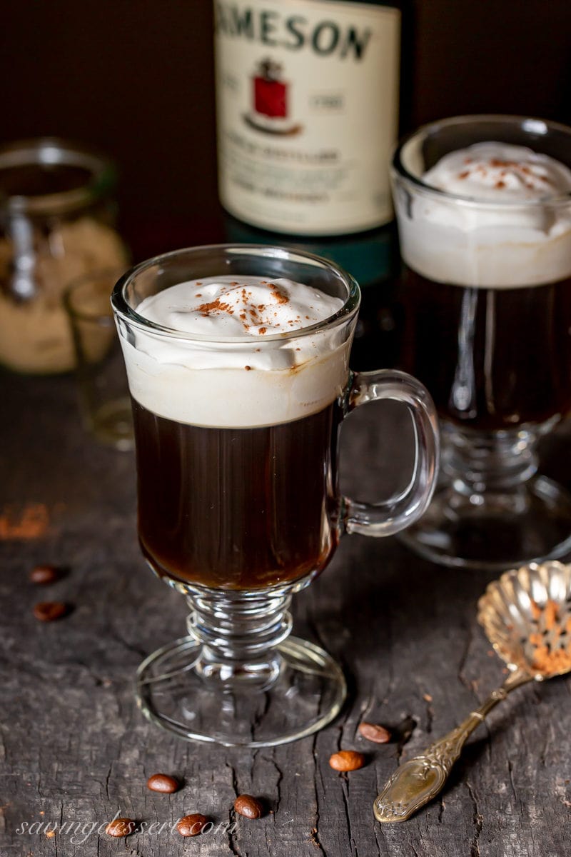 Mugs of hot Irish Coffee with lightly whipped cream on top 