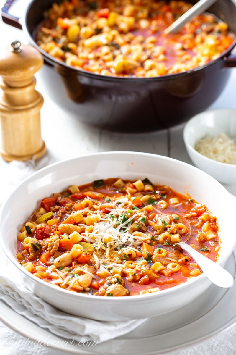 A bowl of Pasta e Fagioli soup topped with fresh grated Parmesan cheese and parsley