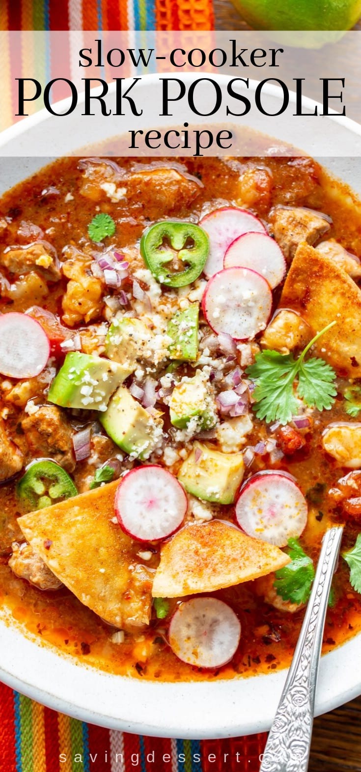 A bowl of pork posole garnished with chips, radishes and hot peppers