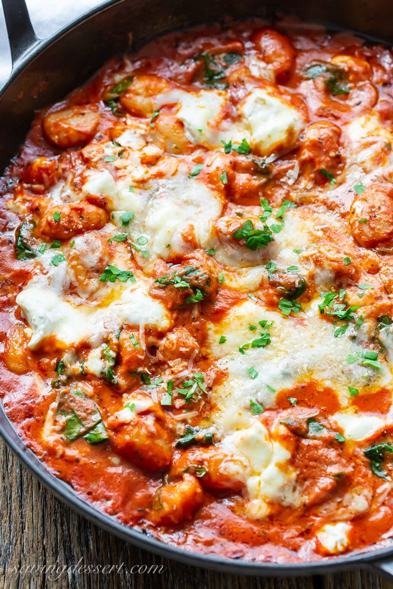 A skillet of baked tomato gnocchi with three cheeses