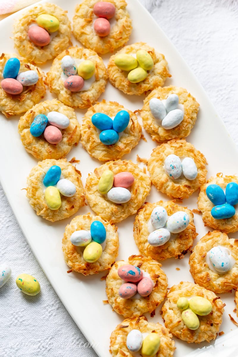 A plate of Coconut Thumbprint Cookies with speckled candy eggs in the middle