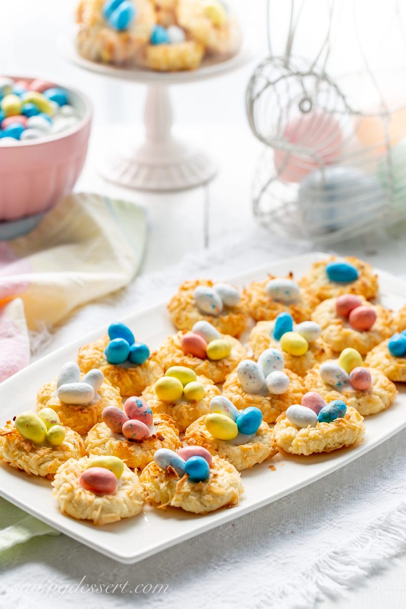 a tray of coconut thumbprint cookies with speckled candy eggs in the middle