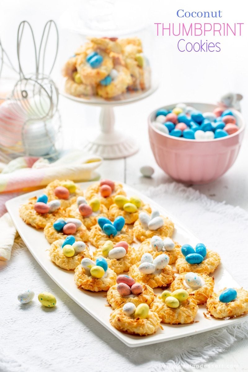 A plate of Coconut Thumbprint Cookies with speckled candy eggs in the middle