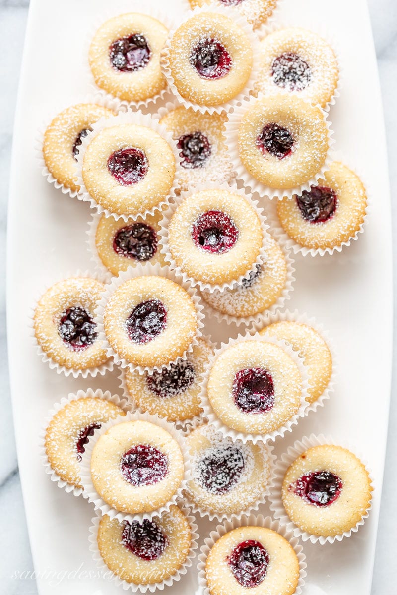 Little Almond Tea Cakes filled with blueberry jam on a platter