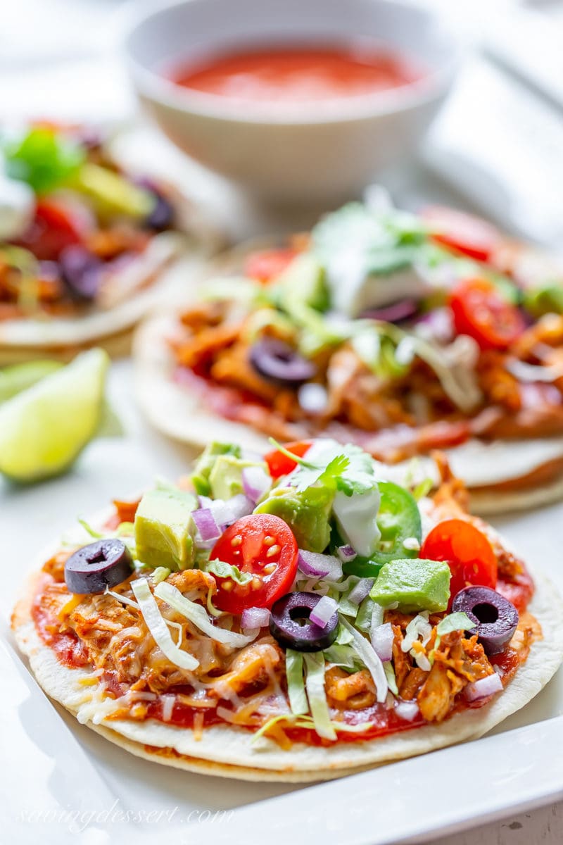 Easy Mexican Pizza with tomatoes, olives, shredded lettuce, spicy chicken and onions