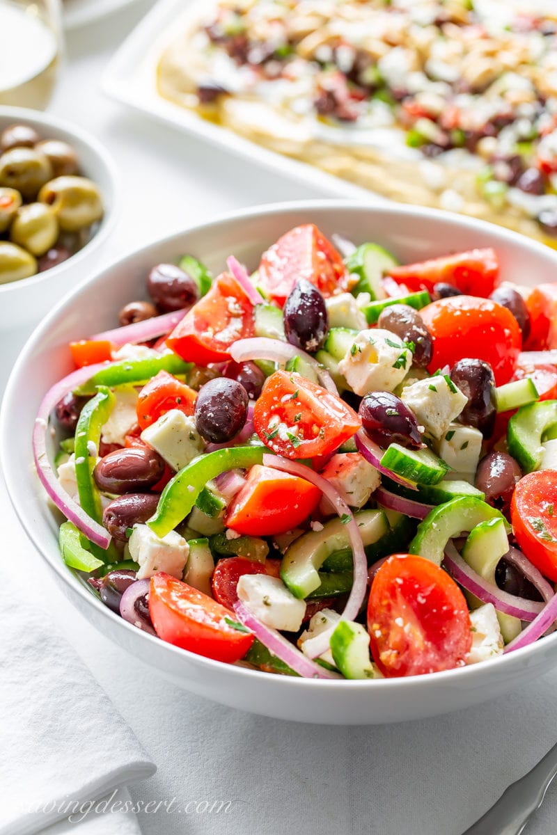 A bowl of Greek salad with olives, tomatoes, bell pepper and cheese