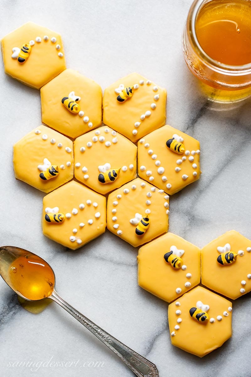 A sugar cookie recipe cut out into a hexagonal shape decorated with honey bees