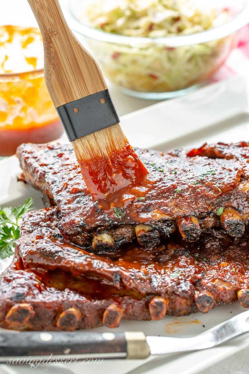 Racks of slow cooked St. Louis-style pork ribs brushed with sweet bbq sauce
