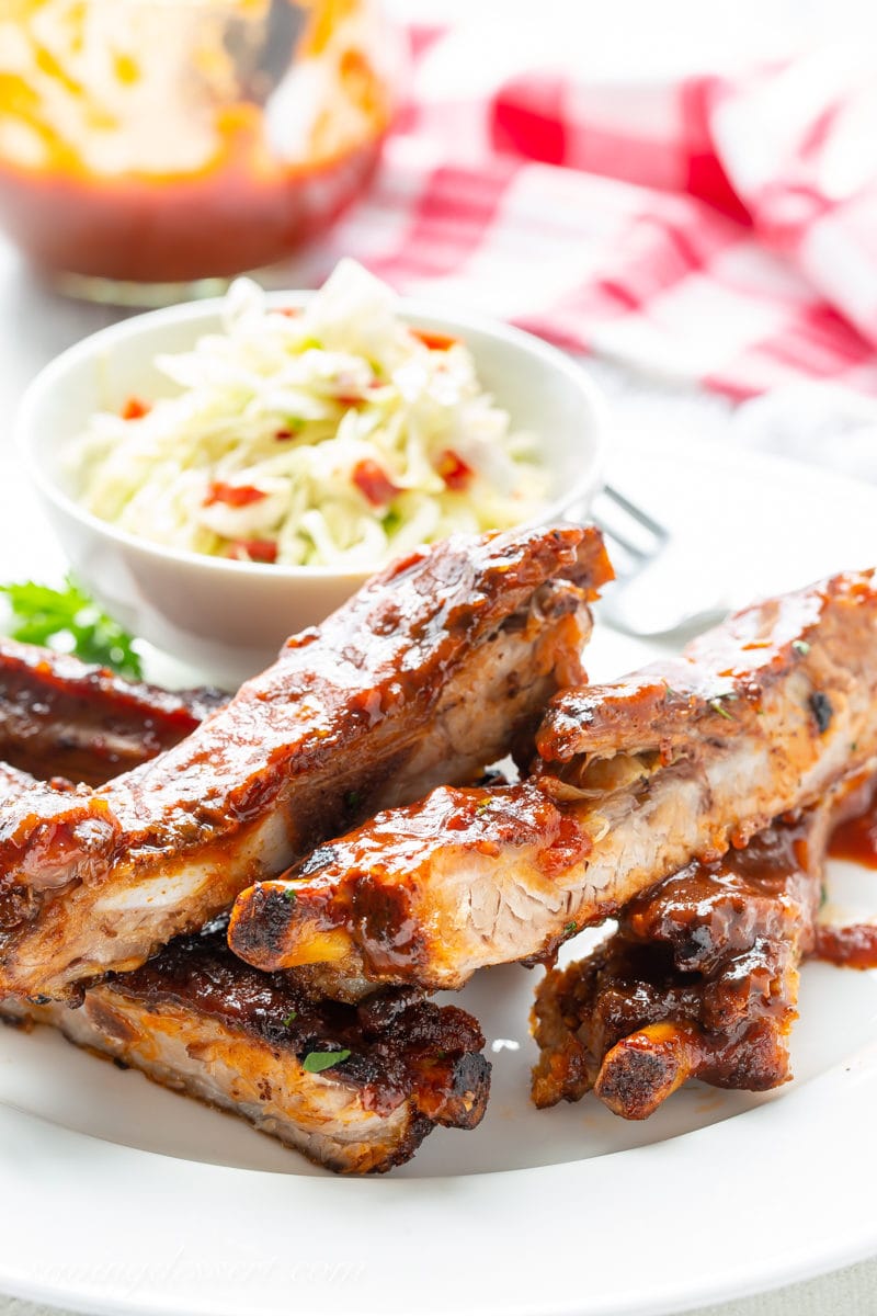 A plate with barbecued ribs with coleslaw and homemade sauce