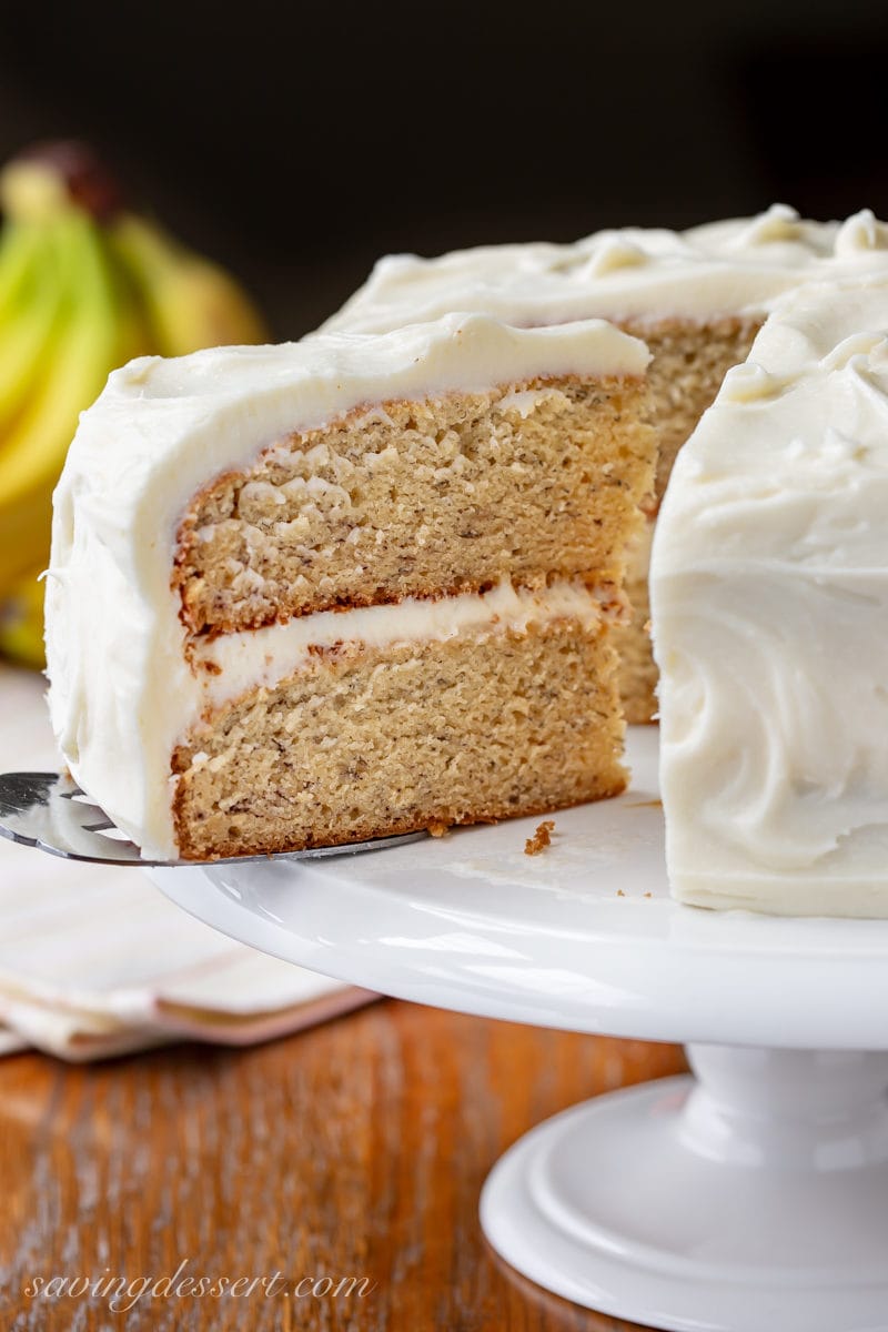 A slice from a two layer banana cake frosted with cream cheese icing