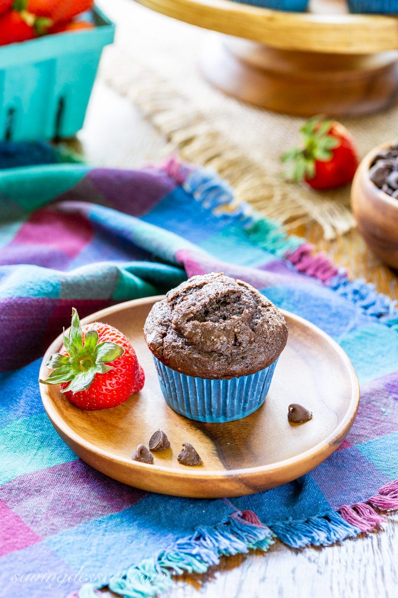 A dark chocolate muffin served with fresh strawberries