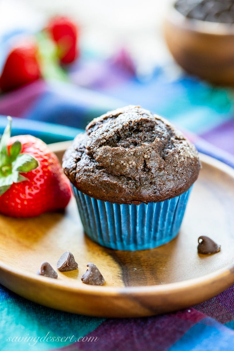 A dark chocolate muffin with chocolate chips and fresh strawberries
