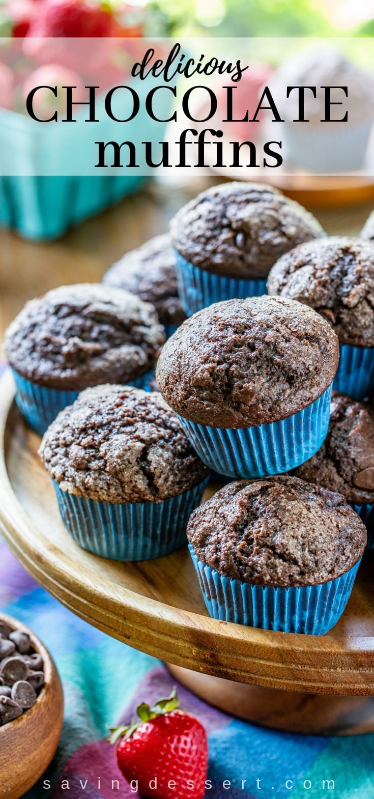 A tray of dark chocolate muffins served with fresh strawberries