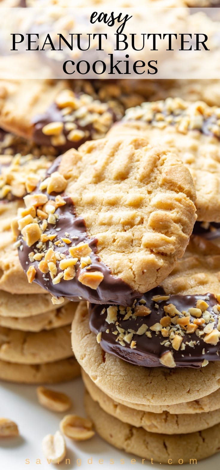 a stack of chocolate dipped peanut butter cookies sprinkled with chopped, salted peanuts