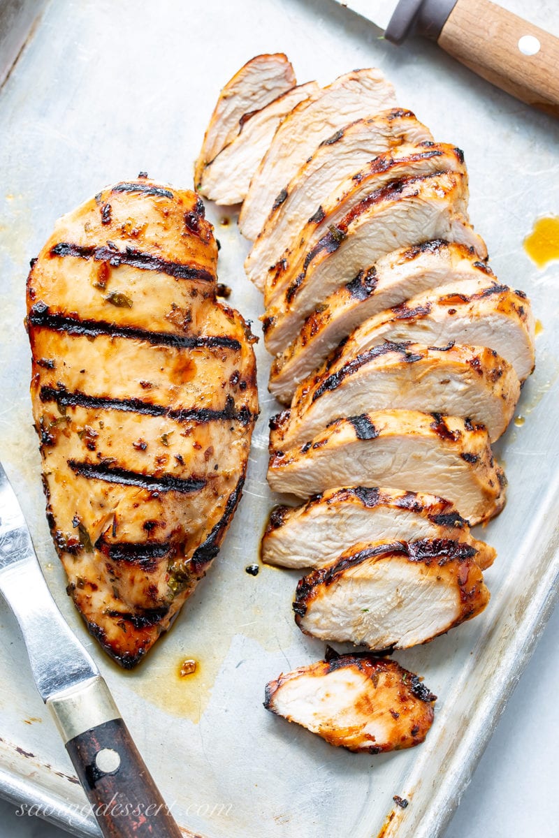 Sliced grilled chicken breasts on a tray