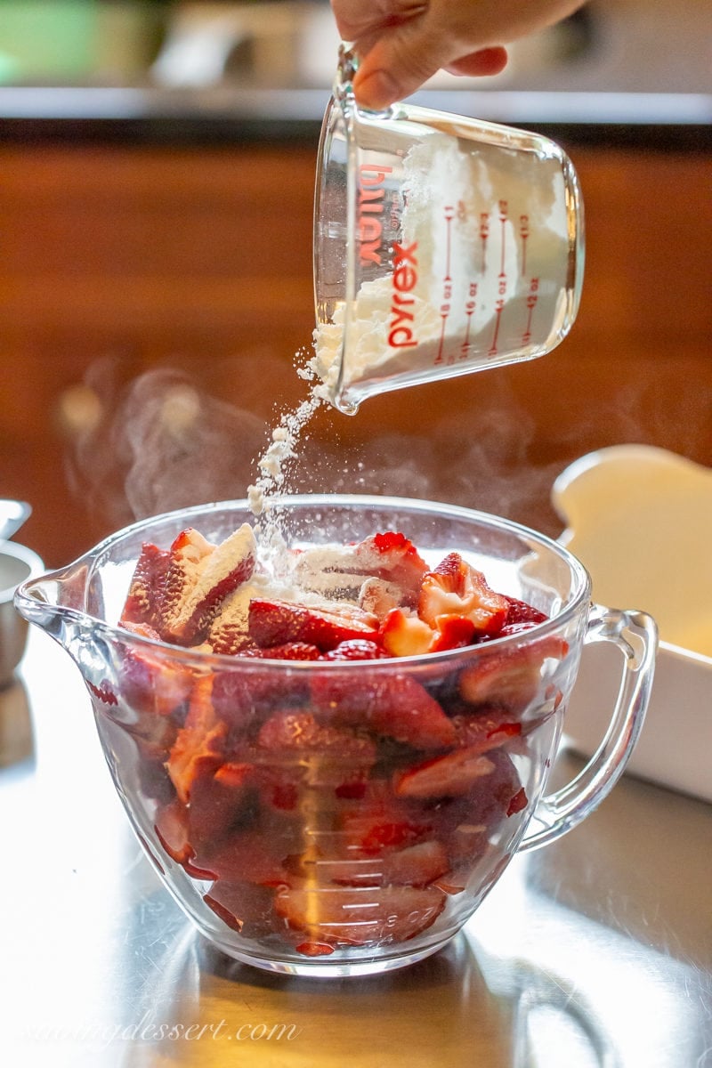 A bowl of strawberries mixed with sugar and cornstarch