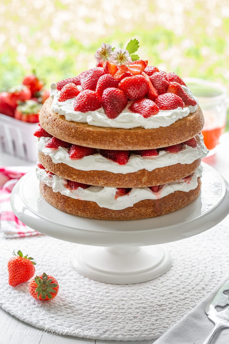 A three layer strawberry shortcake cake filled with cream and strawberries