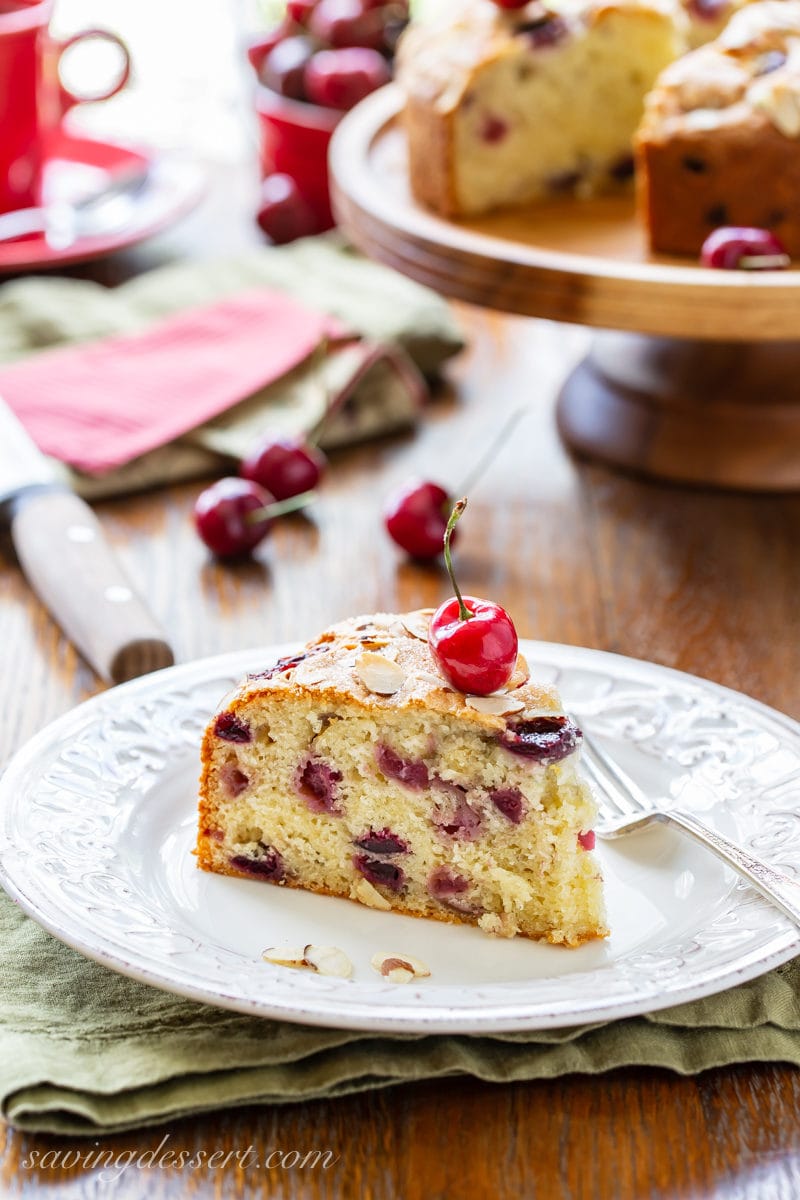 a piece of cherry almond breakfast cake garnished with a fresh red cherry