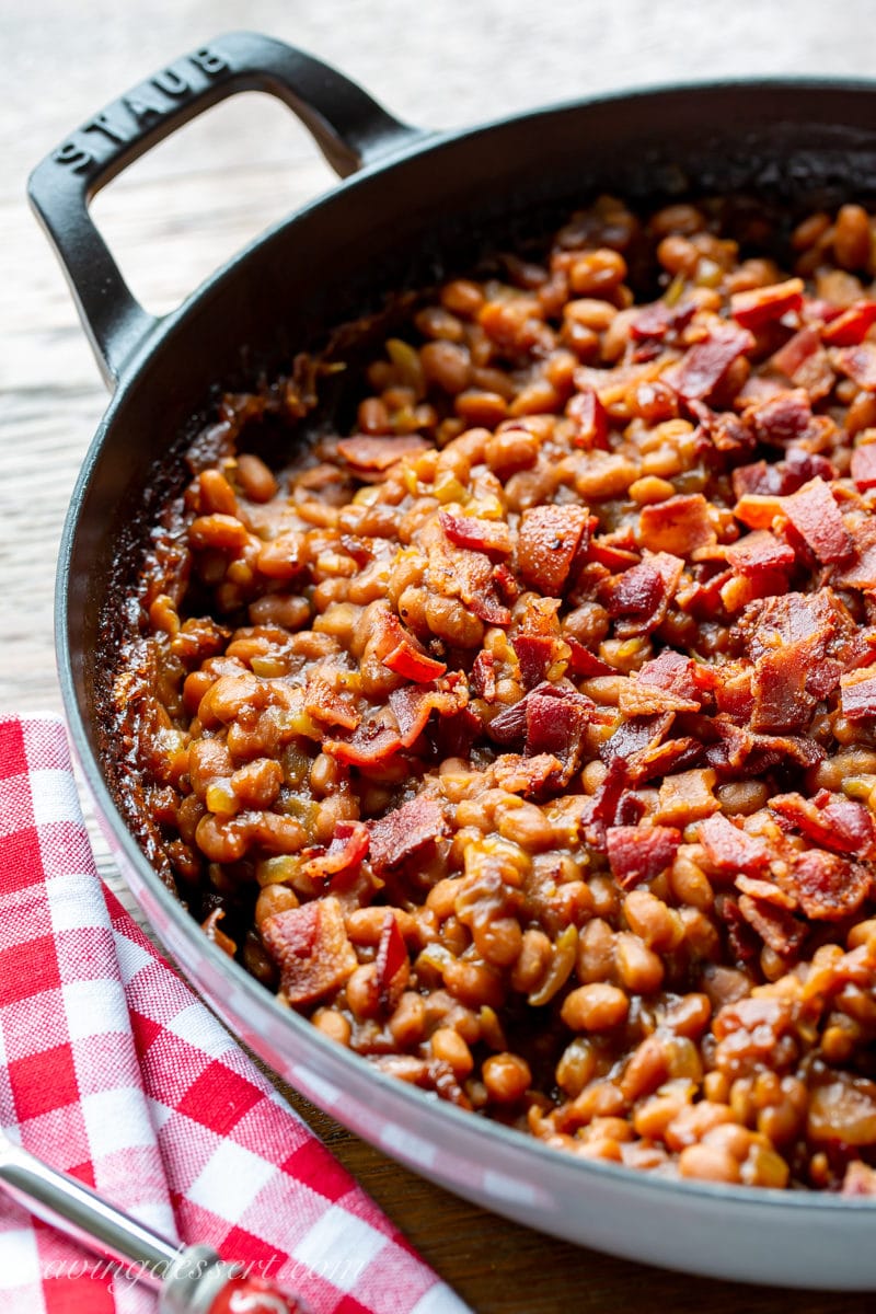 A casserole filled with oven baked beans topped with crumbled bacon