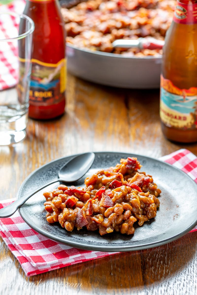 A plate with oven baked beans topped with bacon