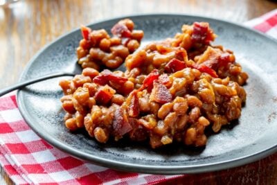 A casserole filled amongst oven baked beans topped amongst crumbled bacon Easy Oven Baked Beans Recipe